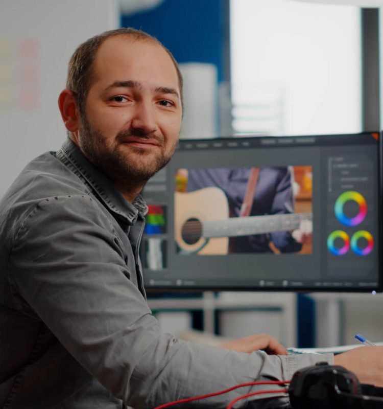 videographer-smiling-at-camera-working-on-computer.jpg